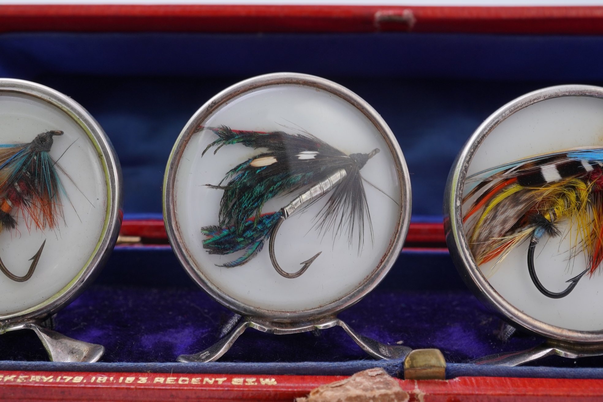 A set of four early 20th century silver mounted fishing related novelty menu holders, by Grey & Co, housed in a red leather case with gilt initials RV
